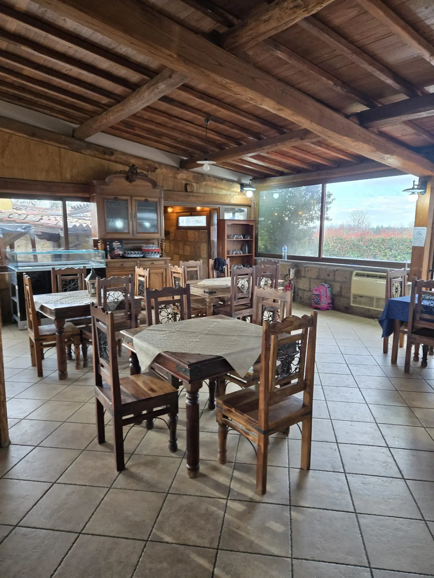 Sala interna con travi in legno e tavoli apparecchiati