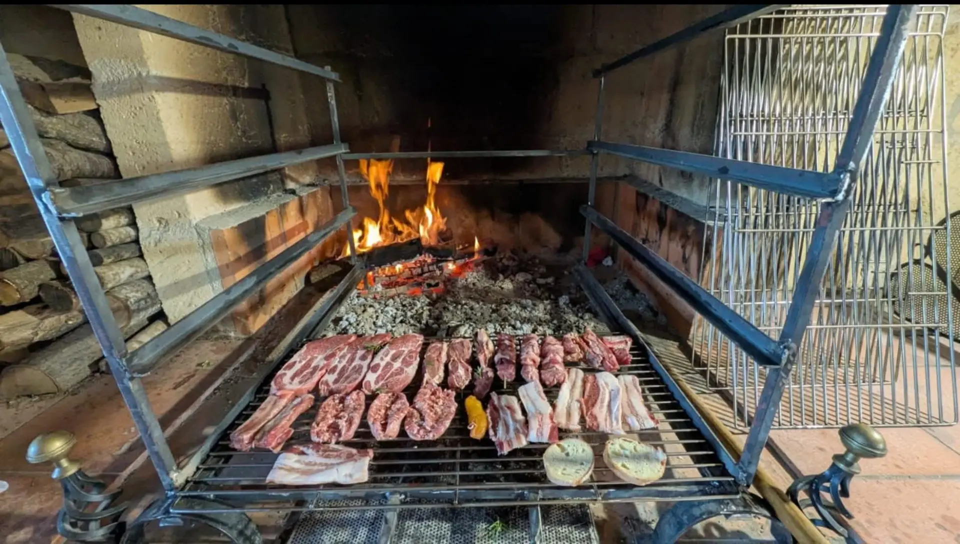 Griglia piena di carne e pane in cottura