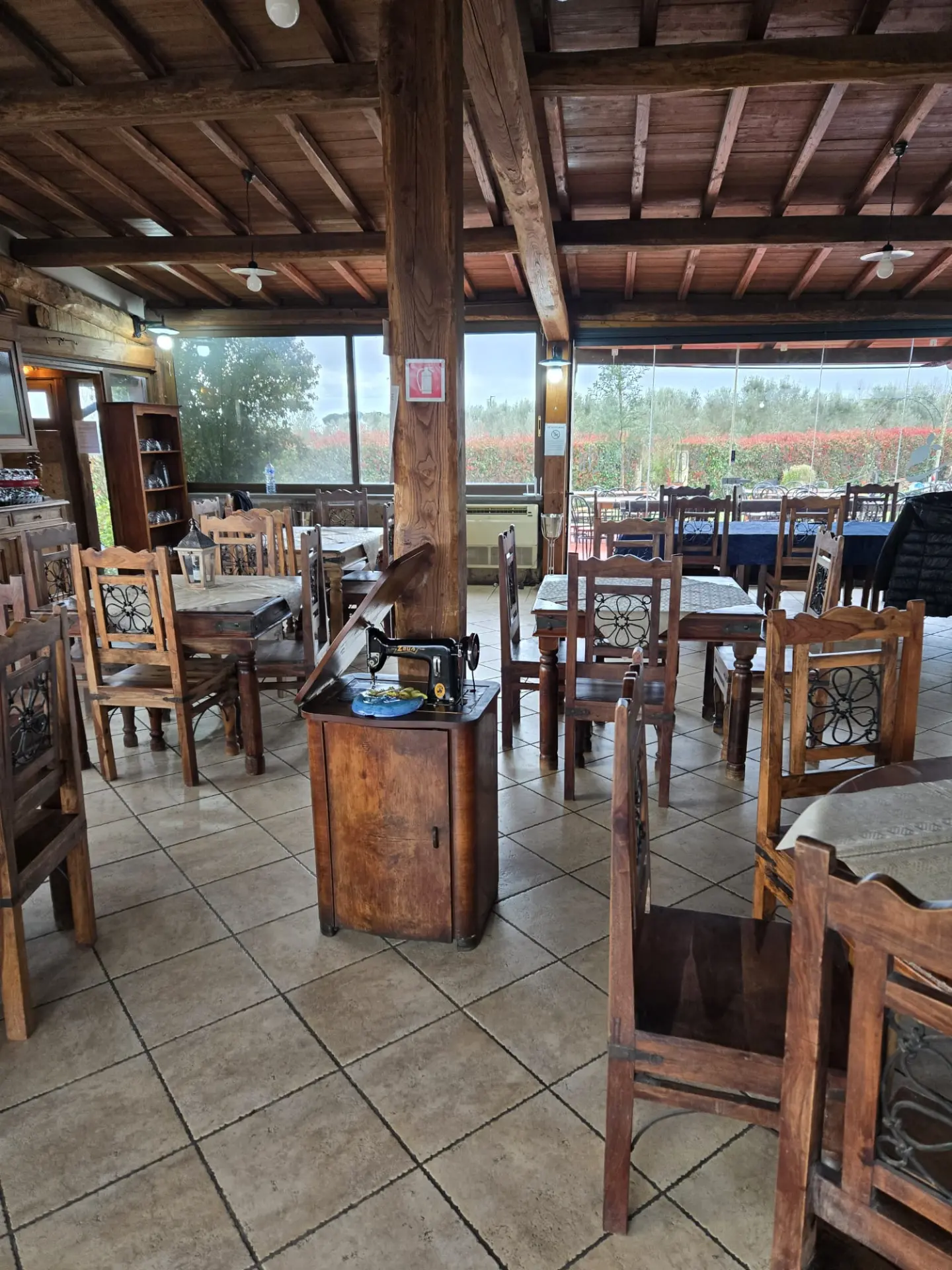 Sala del ristorante con tavoli in legno e vista sulla campagna